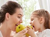 mom and child eating apple nutrition image